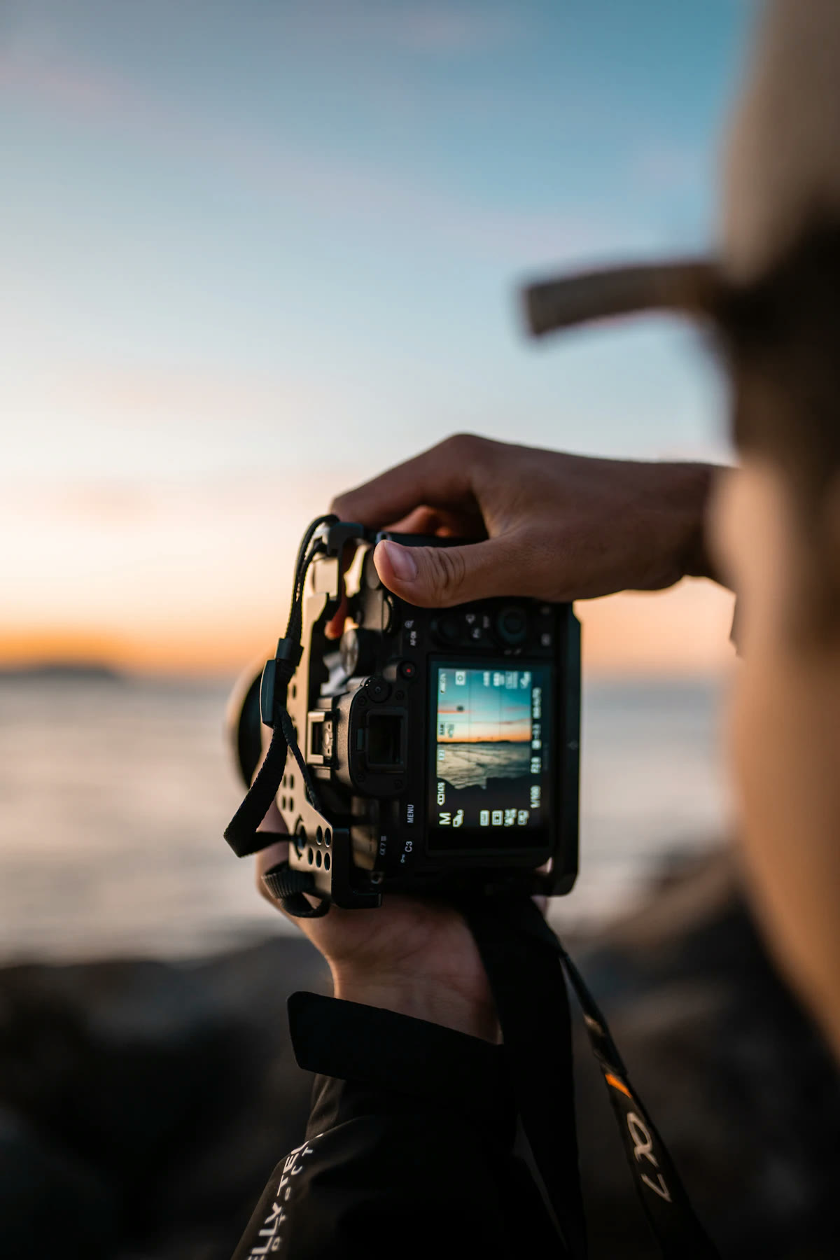 Fotógrafo capturando el atardecer con una cámara profesional
