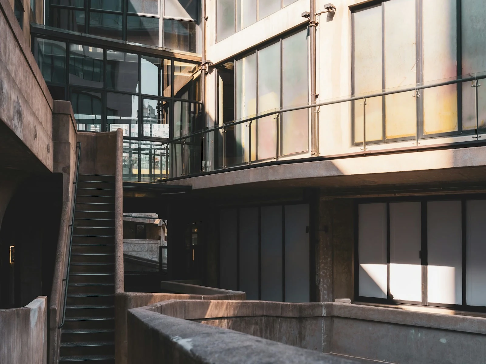 Interior arquitectónico contemporáneo con escaleras, vidrio y luz cálida