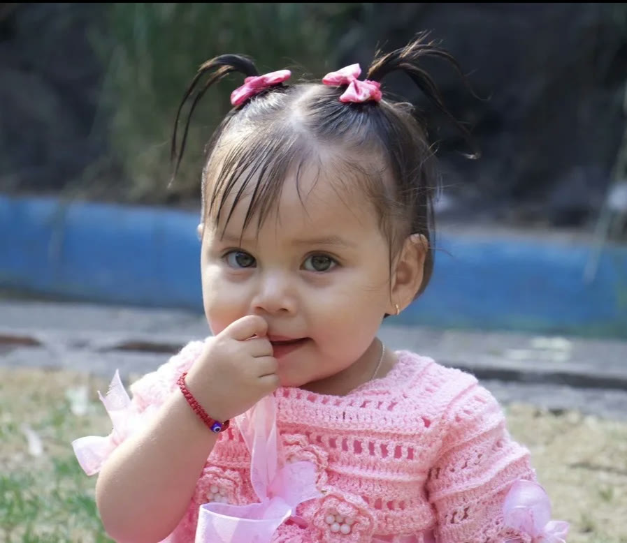 Retrato de bebé con vestido rosa tejido