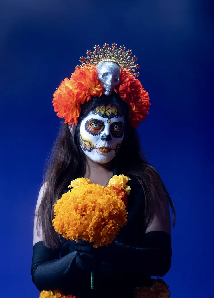 Retrato con maquillaje de Catrina y flores de cempasúchil